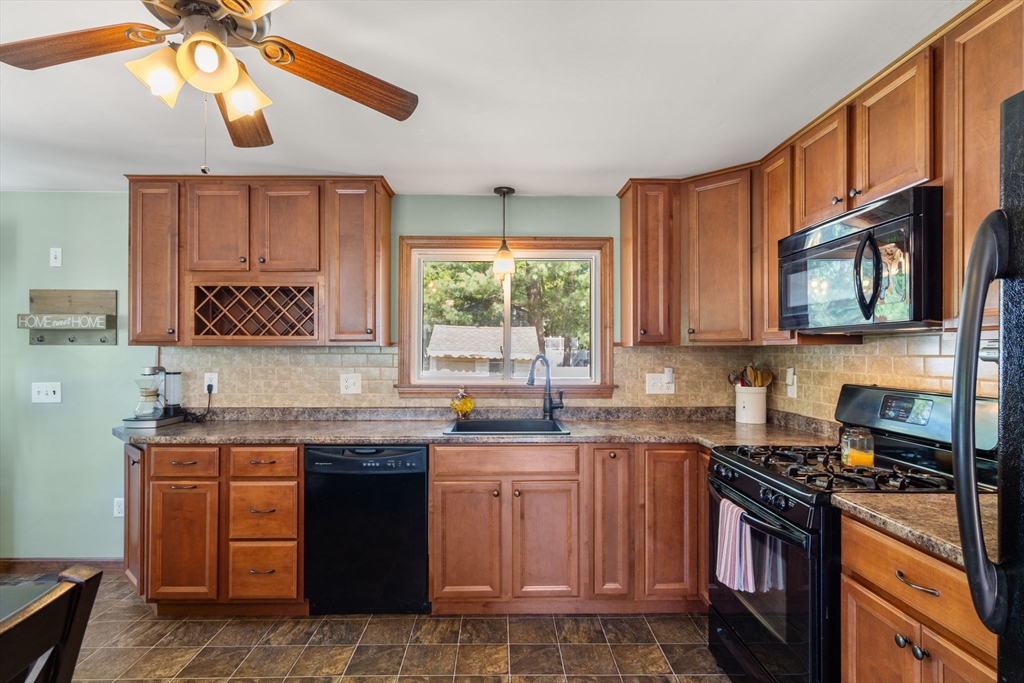 3 Norman Road Billerica, MA 01821 - Photo 10 of 28 a kitchen with stainless steel appliances granite countertop a sink a stove a oven a window with wooden floor and cabinets