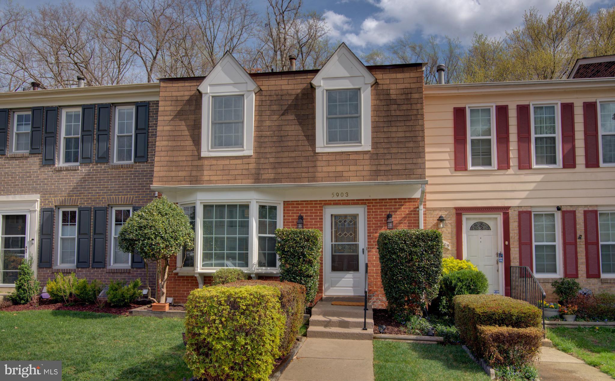 front view of house with a yard and potted plants