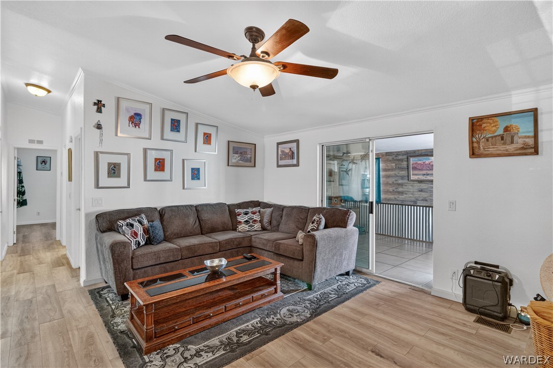 784 Pegasus Ranch Road Bullhead City, AZ 86429 - Photo 20 of 100 Living area featuring wood-finish flooring, a ceiling fan with integrated lighting, and white baseboards