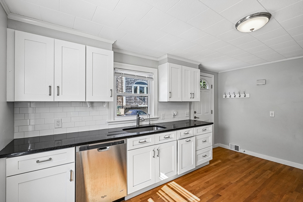 42 East Main Street Gloucester, MA 01930 - Photo 17 of 25 a kitchen with granite countertop white cabinets and white appliances