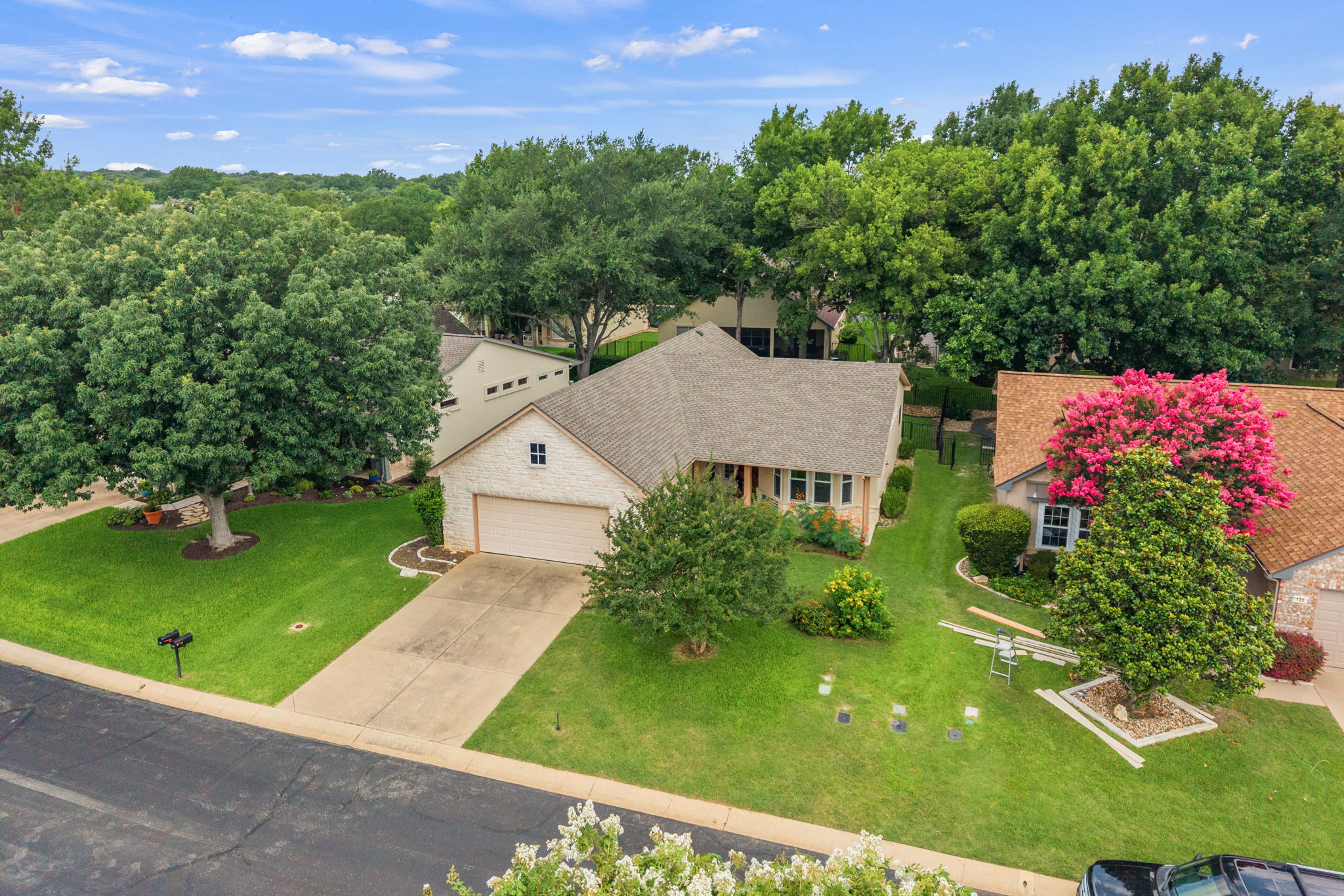 118 Bass Street Georgetown, TX 78633 - Photo 4 of 40 A welcoming home framed by mature trees, showcasing a well-maintained lawn and an inviting front exterior.