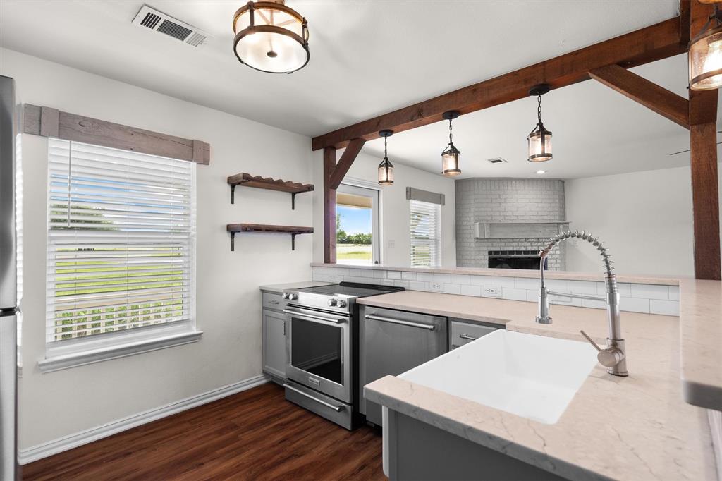 13132 Highway 78 Blue Ridge, TX 75424 - Photo 11 of 35 Open-concept kitchen featuring wood-finish flooring, stainless steel appliances, a white farmhouse sink, light countertops, and a subway tile backsplash