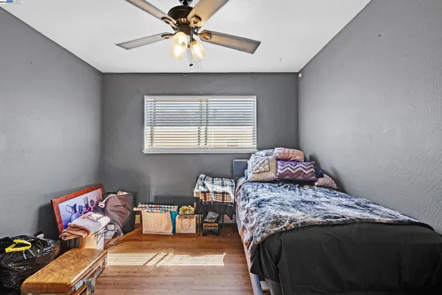 a bedroom with a bed and wooden floor