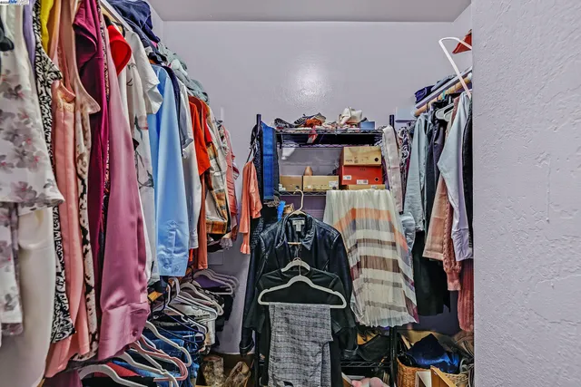 a view of walk in closet with clothes