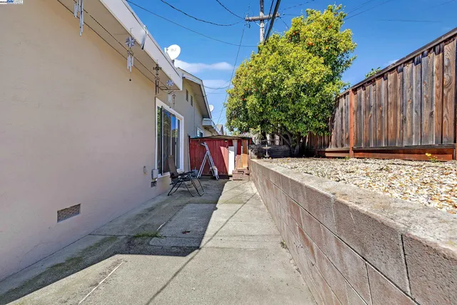 a view of a backyard with a patio and wooden fence