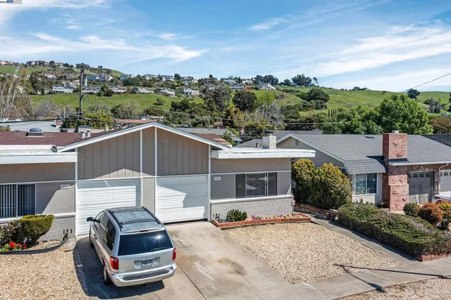 a front view of a house with a garden and mountain view