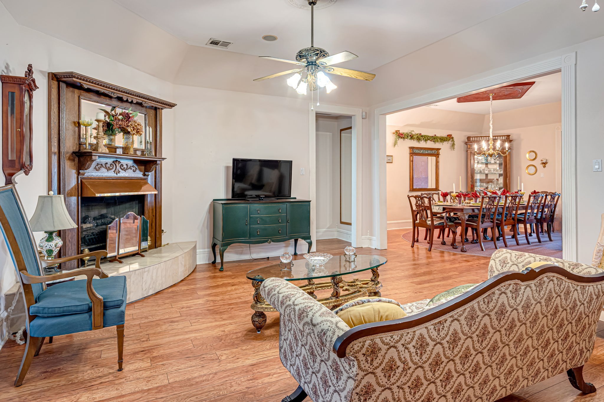 4028 Crosby Cedar Bayou Road Baytown, TX 77521 - Photo 20 of 35 Another view of the living room—hardwoods and a decorative fireplace, with a doorway to the primary suite and a wide opening to the formal dining room.
