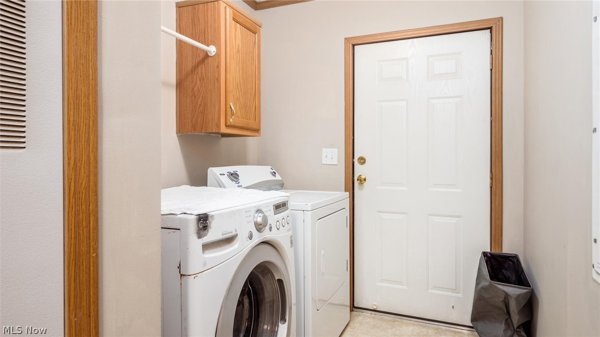 9180 North River Road East Dresden, OH 43821 - Photo 30 of 36 Laundry room featuring cabinets, light tile floors, and separate washer and dryer