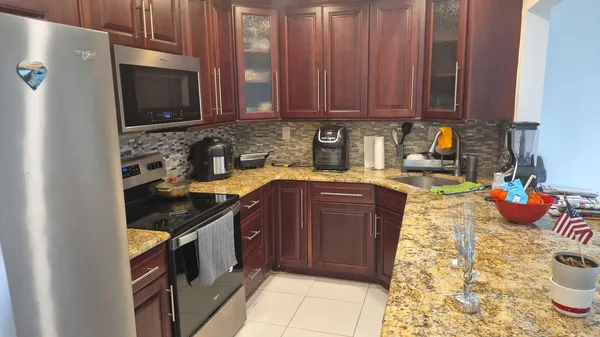 a kitchen with stainless steel appliances granite countertop a sink stove and cabinets