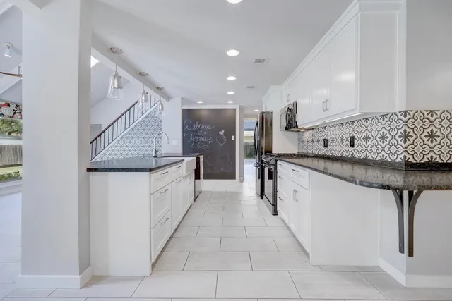 a kitchen with stainless steel appliances granite countertop a sink and a refrigerator