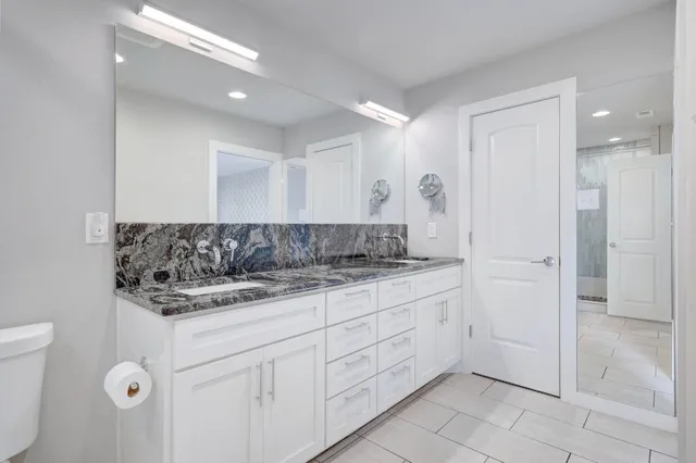 a bathroom with a granite countertop sink and a mirror