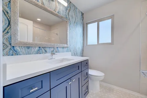 a bathroom with a sink a toilet and a mirror