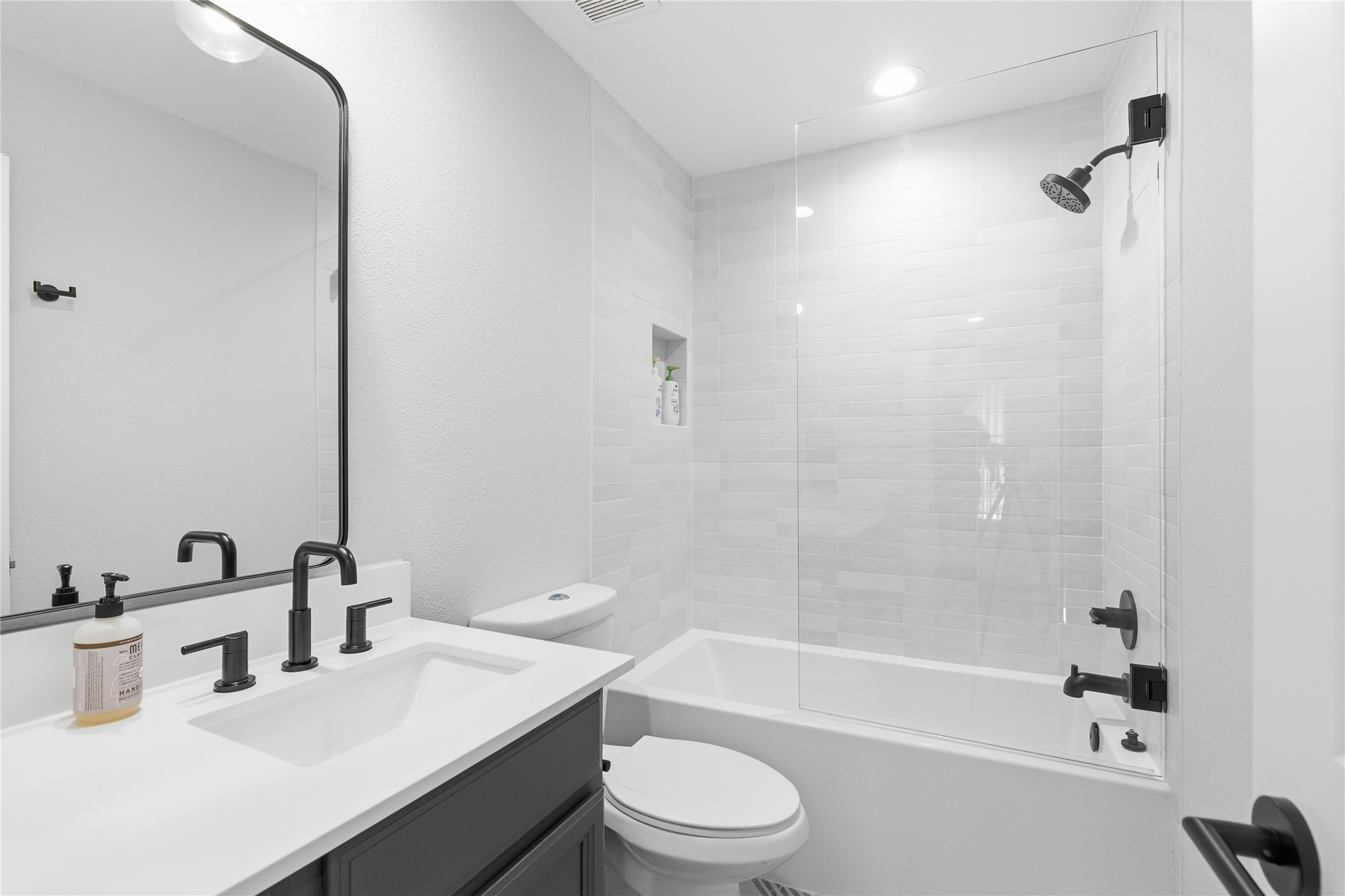 501 Lightsey Road Austin, TX 78704 - Photo 16 of 40 a bathroom with a bathtub shower sink vanity mirror and toilet