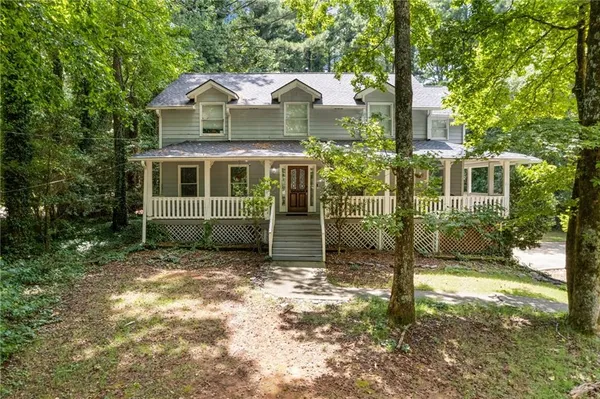 a view of a house with a yard and large tree