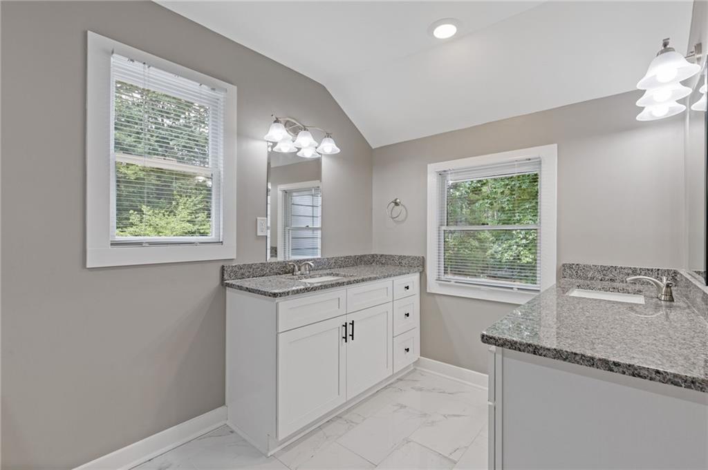 742 Mountain View Drive Stone Mountain, GA 30083 - Photo 26 of 43 a bathroom with a granite countertop sink and a window