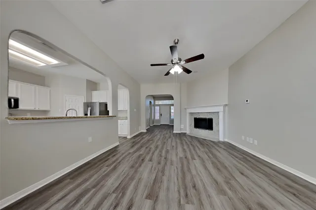 a view of a livingroom with wooden floor and a kitchen