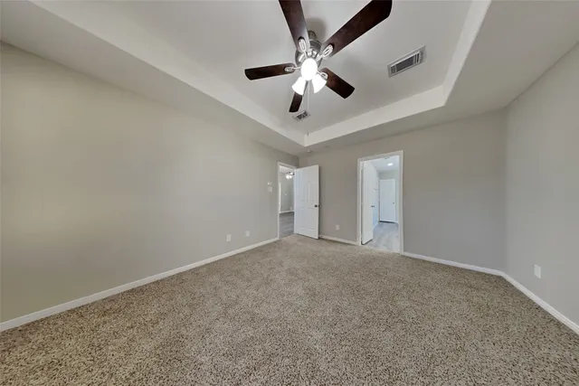 an empty room with a ceiling fan and window