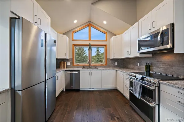 a kitchen with stainless steel appliances a refrigerator sink and microwave