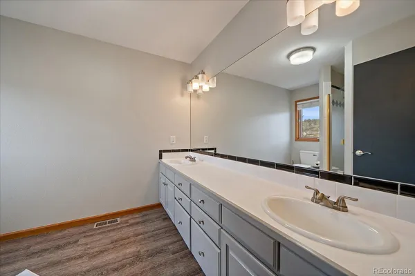 a spacious bathroom with a double vanity sink and a mirror
