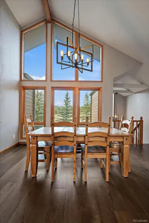 a view of a dining room with furniture a chandelier and wooden floor