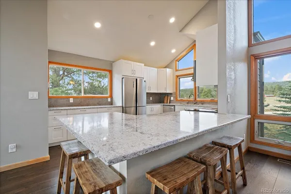 a kitchen with granite countertop sink and wooden floor