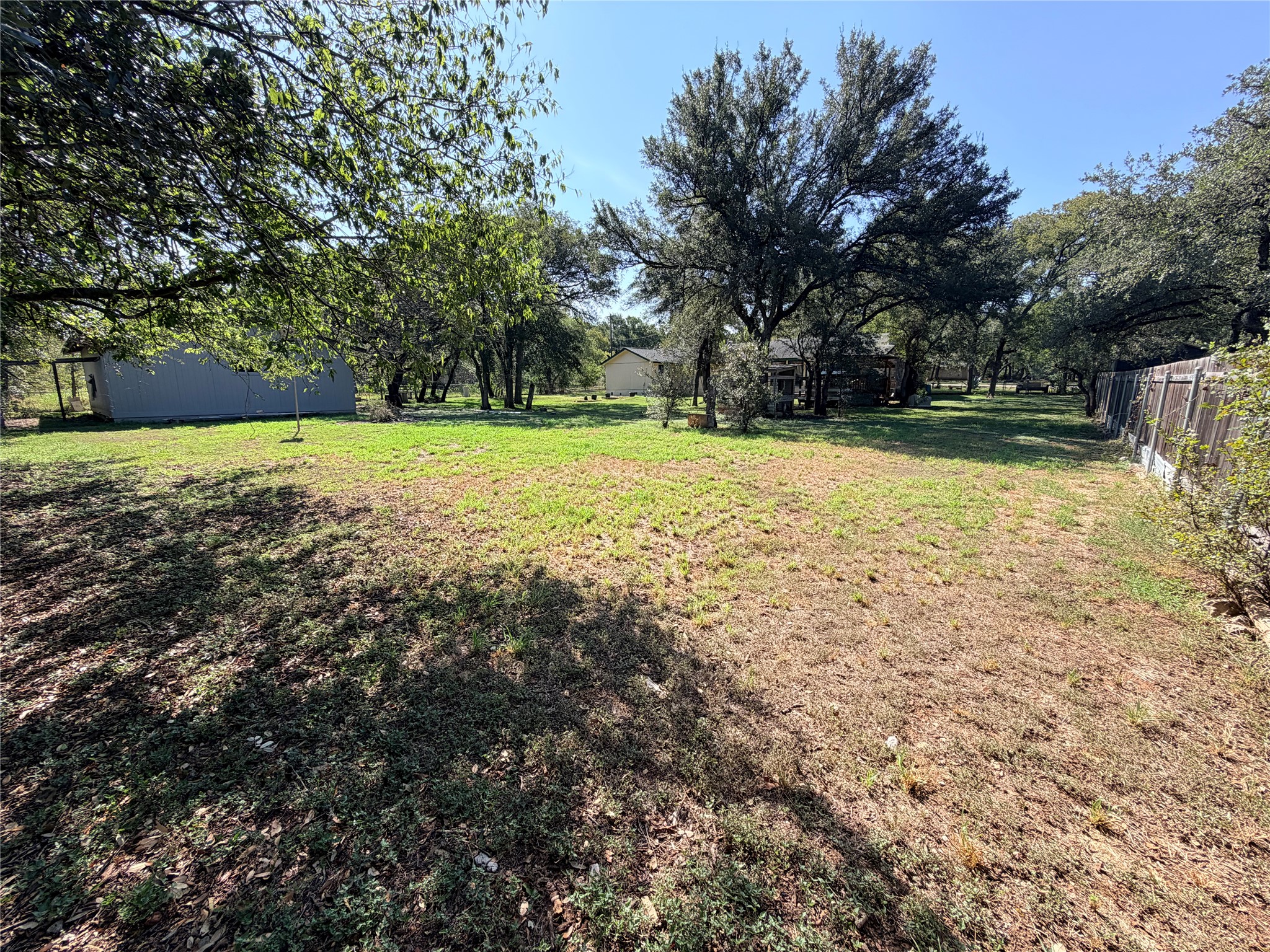2800 Robin Road Manchaca, TX 78652 - Photo 28 of 28 Mature trees frame a spacious, fenced lawn behind the main residence.