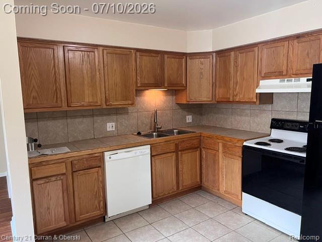 14682 Middle Gibraltar Road, Unit 24 Rockwood, MI 48173 - Photo 6 of 21 Updated Kitchen featuring wood-finish cabinetry, tile countertops, and a full tile backsplash