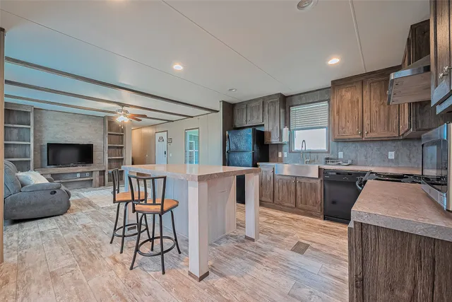 a kitchen with sink a refrigerator and chairs