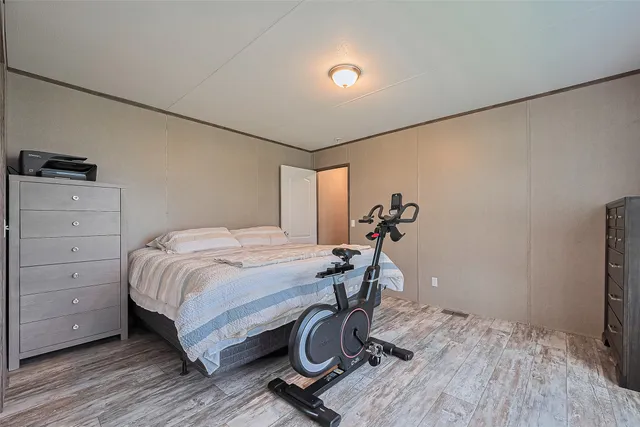 a bedroom with a bed and wooden floor