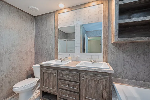 a bathroom with a double vanity sink toilet and a mirror