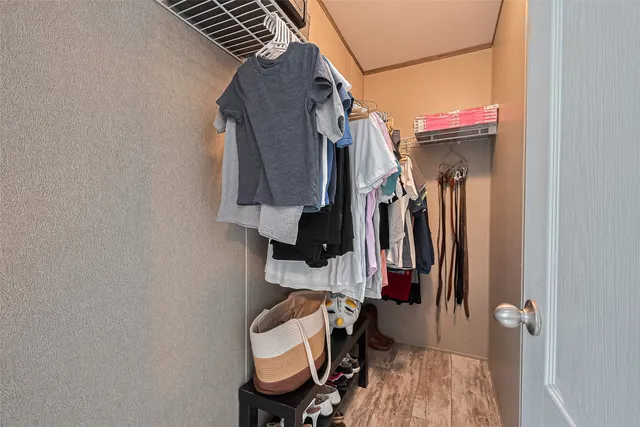 a view of walk in closet with clothes and shoes