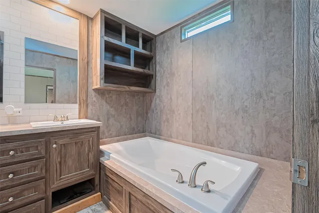 a bathroom with a tub a sink and a window