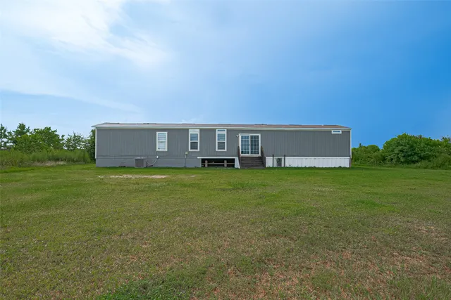 a view of yard with ocean and trees in the background