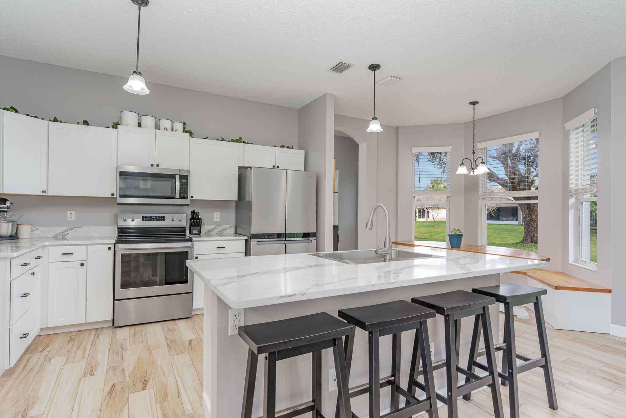 964 Shaw Circle Melbourne, FL 32940 - Photo 3 of 54 a kitchen with granite countertop a table chairs stainless steel appliances and cabinets