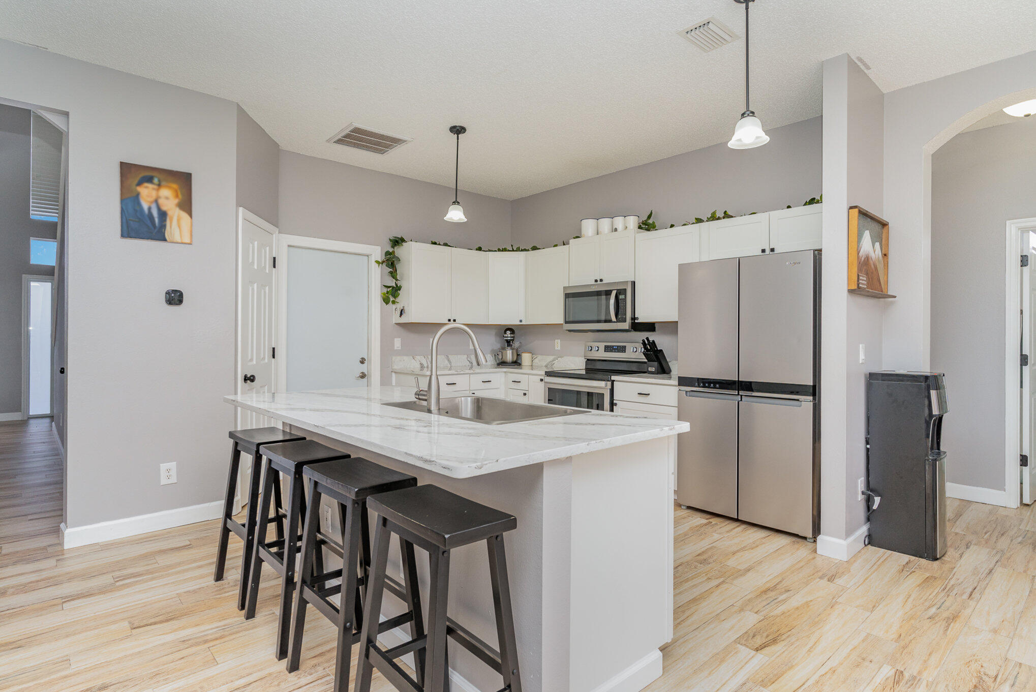 964 Shaw Circle Melbourne, FL 32940 - Photo 35 of 54 a kitchen with stainless steel appliances a refrigerator a sink dishwasher a stove and white cabinets with wooden floor