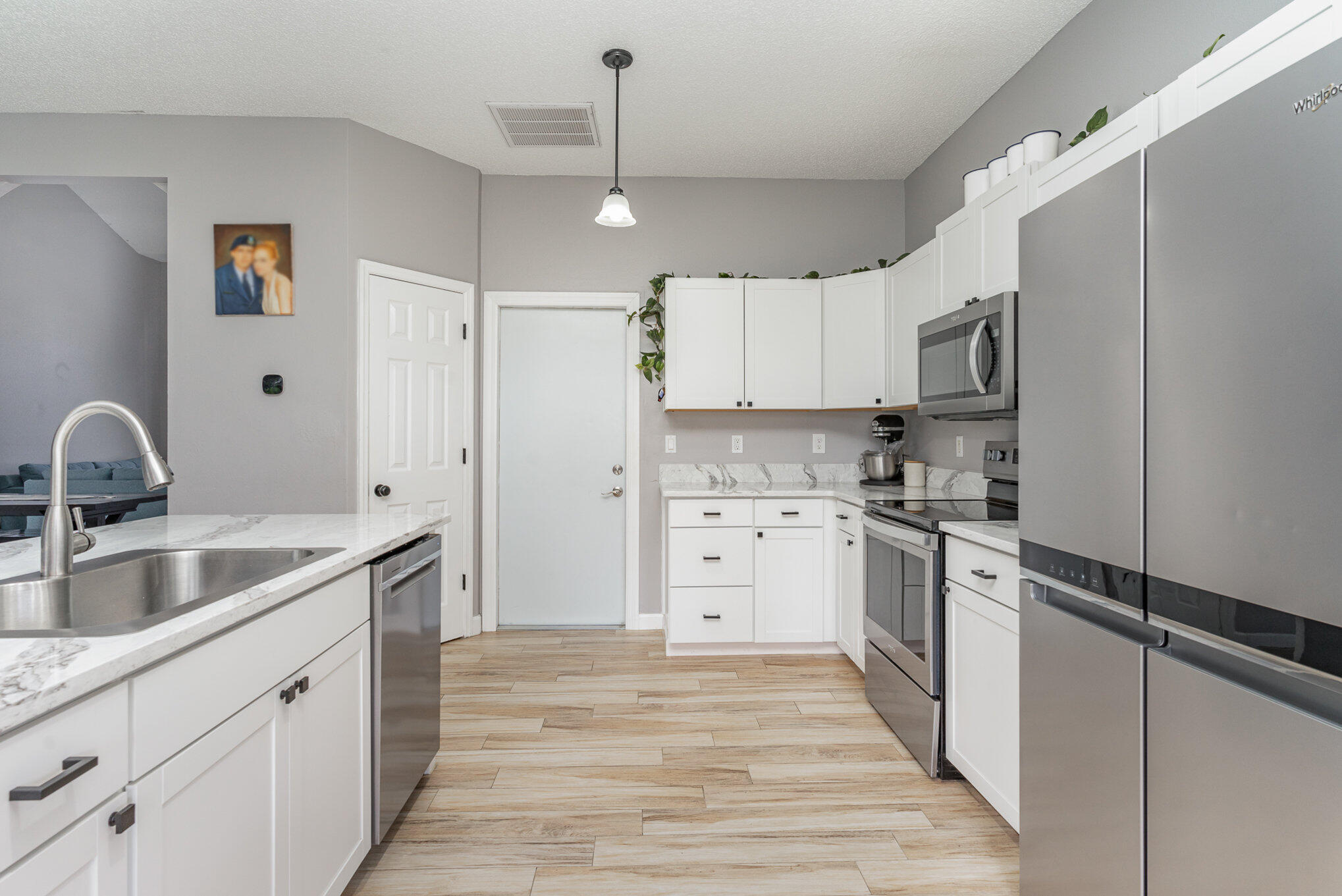 964 Shaw Circle Melbourne, FL 32940 - Photo 36 of 54 a kitchen with white cabinets and stainless steel appliances