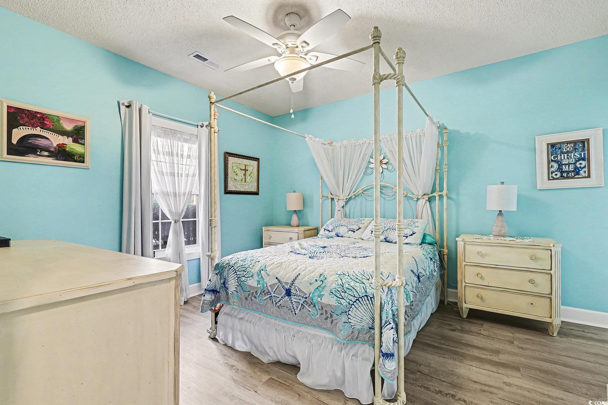 1512 Lanterns Rest Road, Unit 102 Myrtle Beach, SC 29579 - Photo 12 of 21 Bedroom with a textured ceiling, wood finished floors, and a ceiling fan