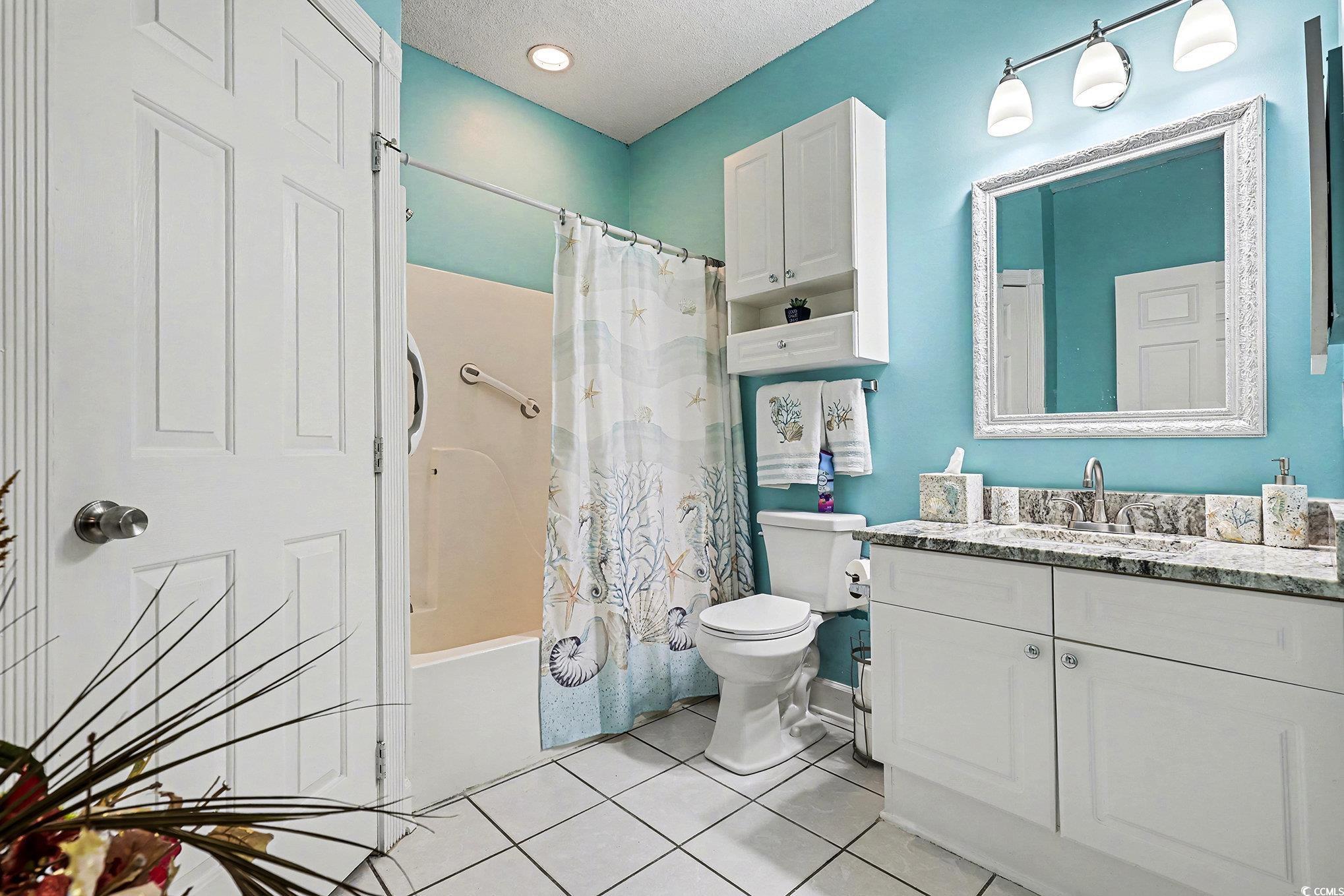 1512 Lanterns Rest Road, Unit 102 Myrtle Beach, SC 29579 - Photo 14 of 21 Bathroom with vanity, shower / bath combination with curtain, light tile patterned floors, and a textured ceiling