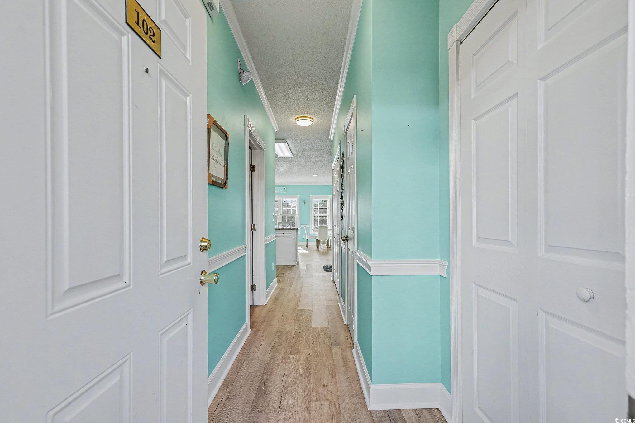 1512 Lanterns Rest Road, Unit 102 Myrtle Beach, SC 29579 - Photo 2 of 21 Corridor featuring ornamental molding, light wood-type flooring, and a textured ceiling