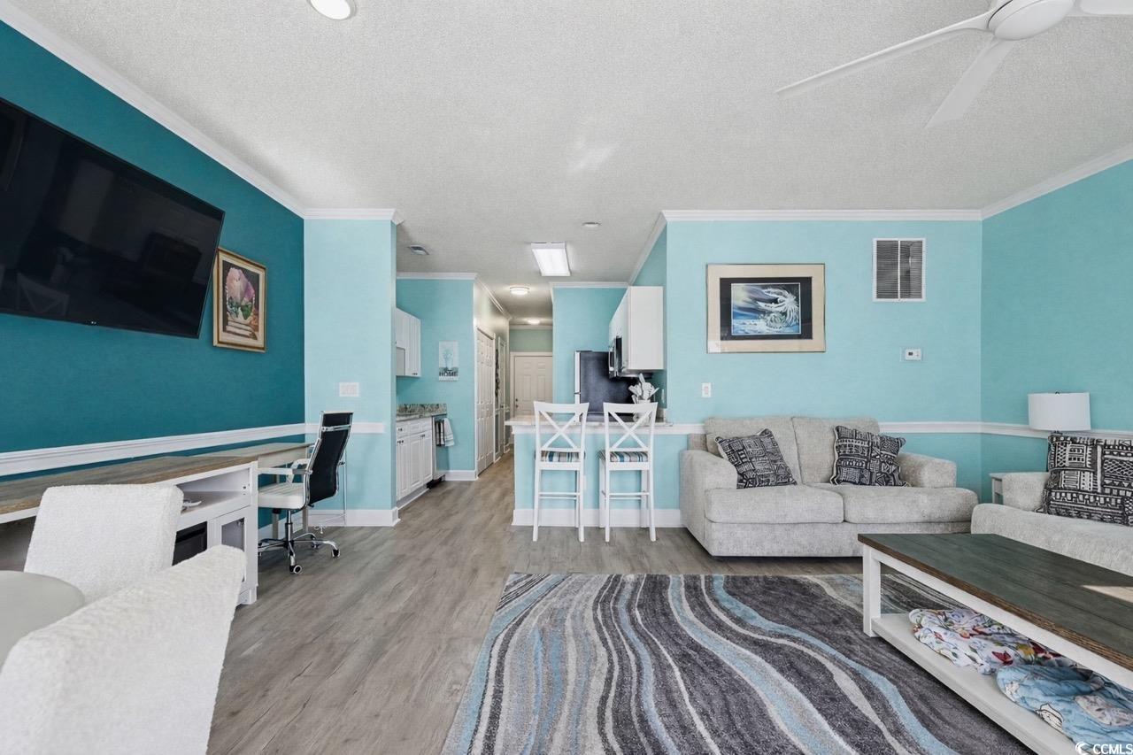 1512 Lanterns Rest Road, Unit 102 Myrtle Beach, SC 29579 - Photo 3 of 21 Living area with light wood-style floors, ornamental molding, a textured ceiling, and built in study area