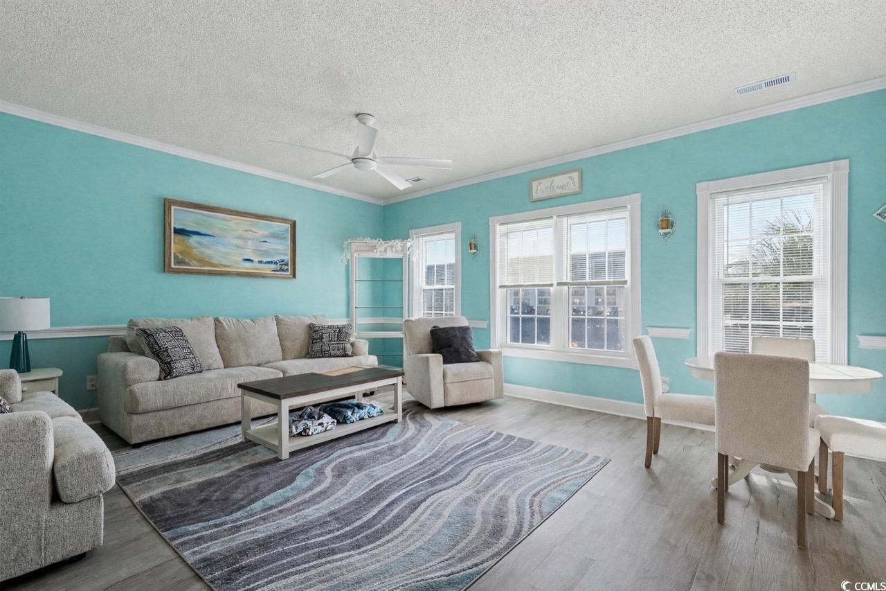 1512 Lanterns Rest Road, Unit 102 Myrtle Beach, SC 29579 - Photo 5 of 21 Living room featuring ornamental molding, a textured ceiling, wood finished floors, and ceiling fan