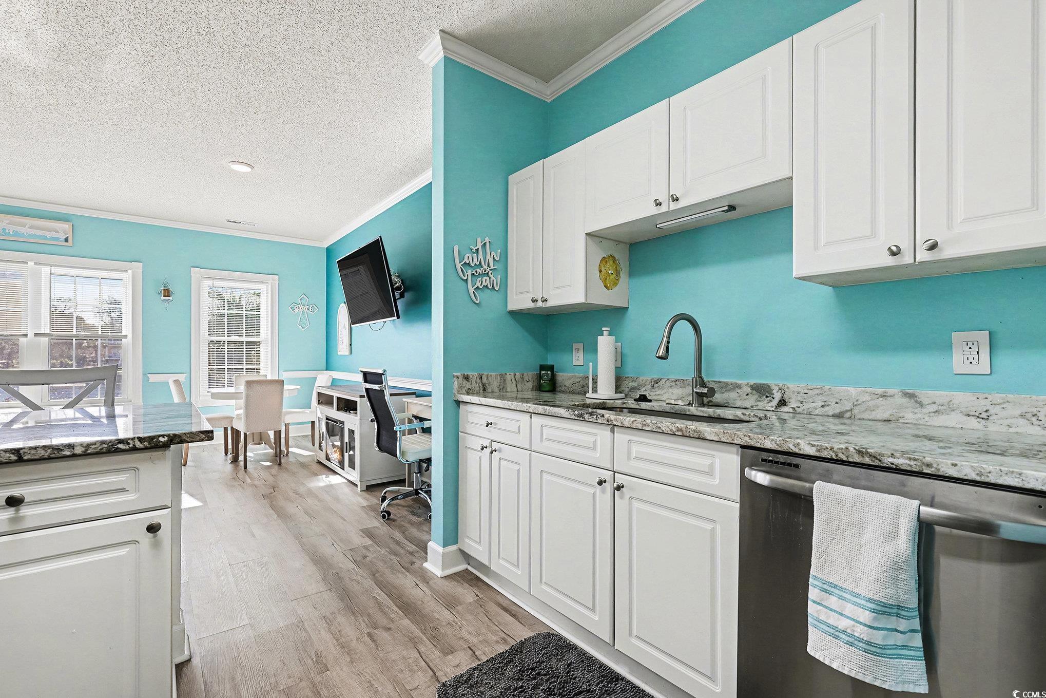1512 Lanterns Rest Road, Unit 102 Myrtle Beach, SC 29579 - Photo 8 of 21 Kitchen featuring stainless steel dishwasher, white cabinets, light stone countertops, a textured ceiling, and ornamental molding