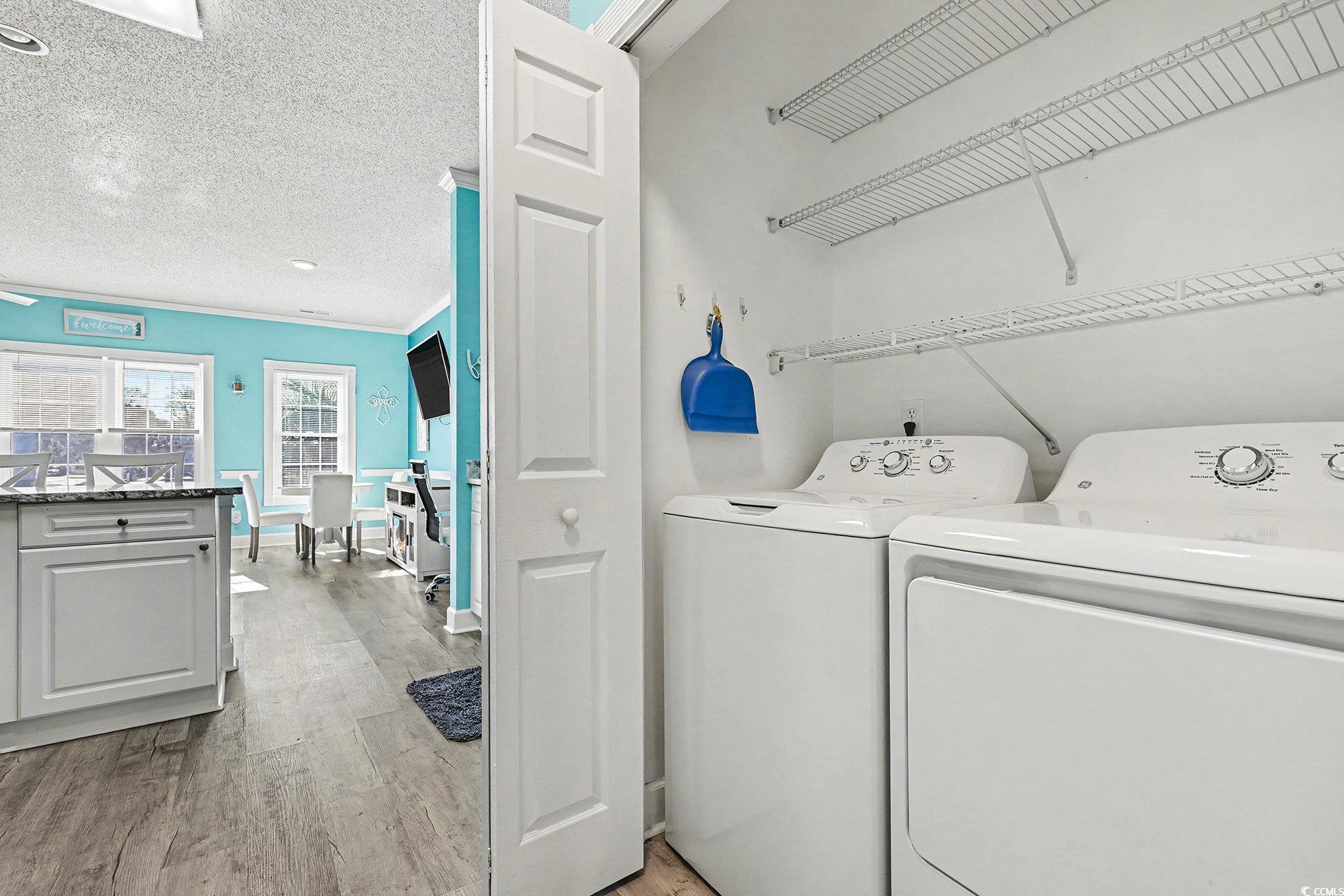 1512 Lanterns Rest Road, Unit 102 Myrtle Beach, SC 29579 - Photo 10 of 21 Laundry area featuring a textured ceiling, light wood-style floors, washer and clothes dryer, and ornamental molding
