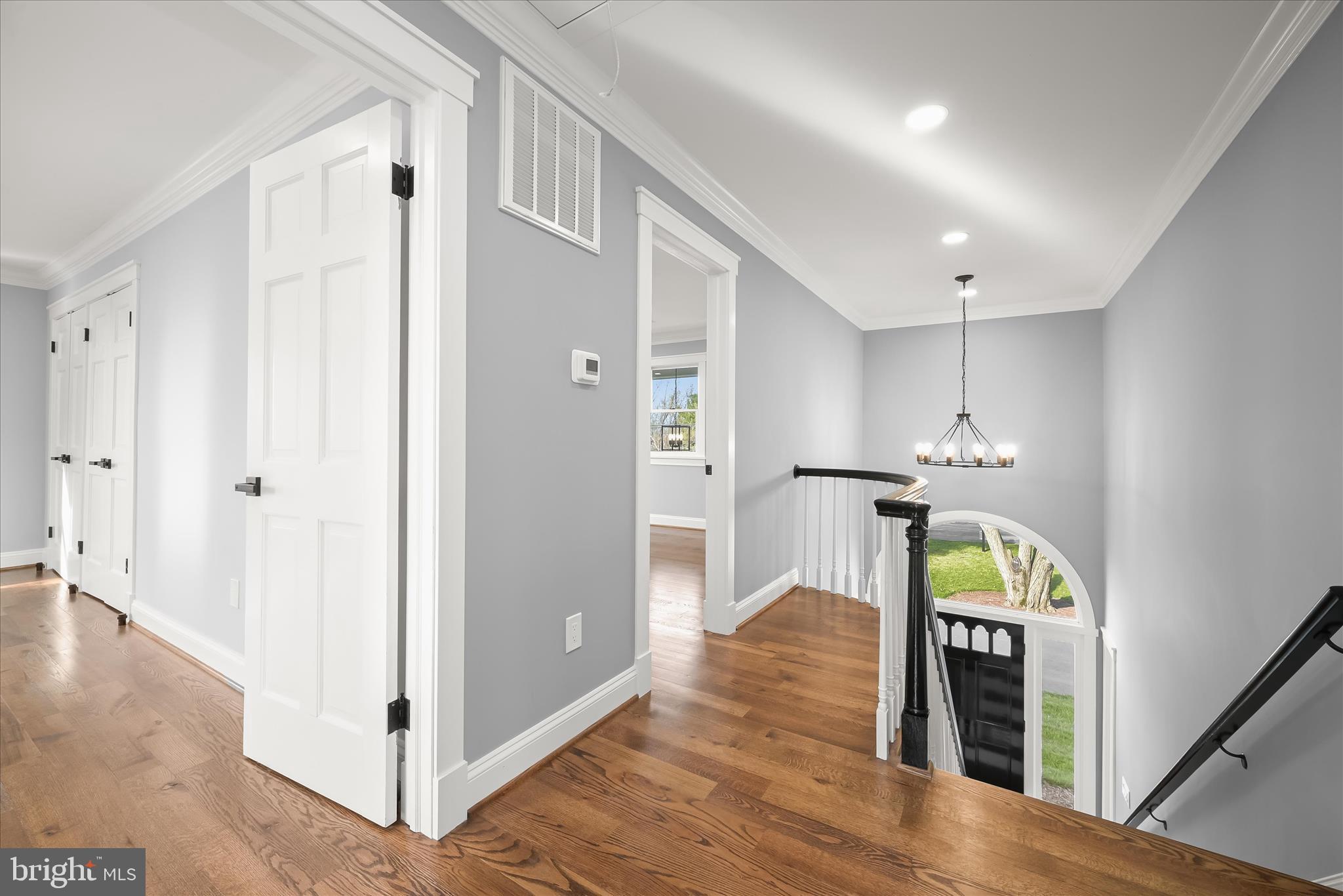 21611 Slidell Road Boyds, MD 20841 - Photo 38 of 84 a view of a hallway with wooden floor stairs and a chandelier