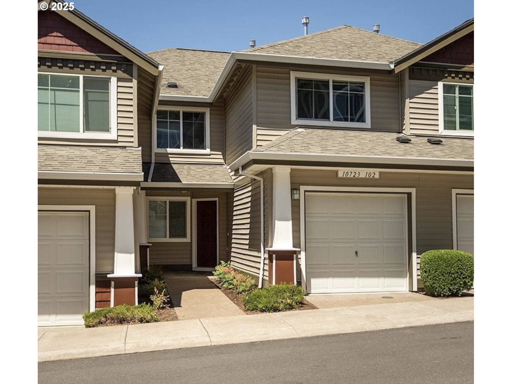 10723 Southwest Canterbury Lane, Unit 102 Portland, OR 97224 - Photo 1 of 30 a front view of a house with a yard and garage