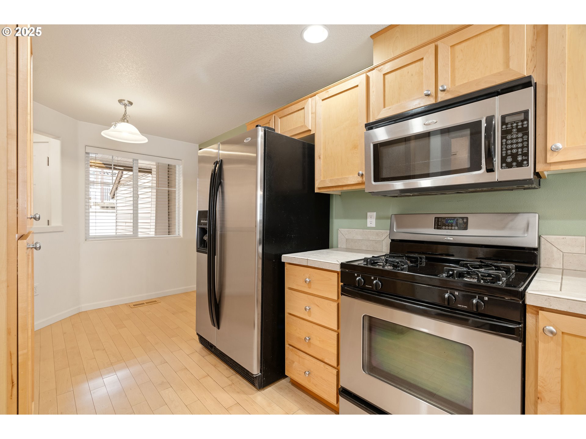 10723 Southwest Canterbury Lane, Unit 102 Portland, OR 97224 - Photo 13 of 30 a kitchen with stainless steel appliances granite countertop a stove a refrigerator and a microwave