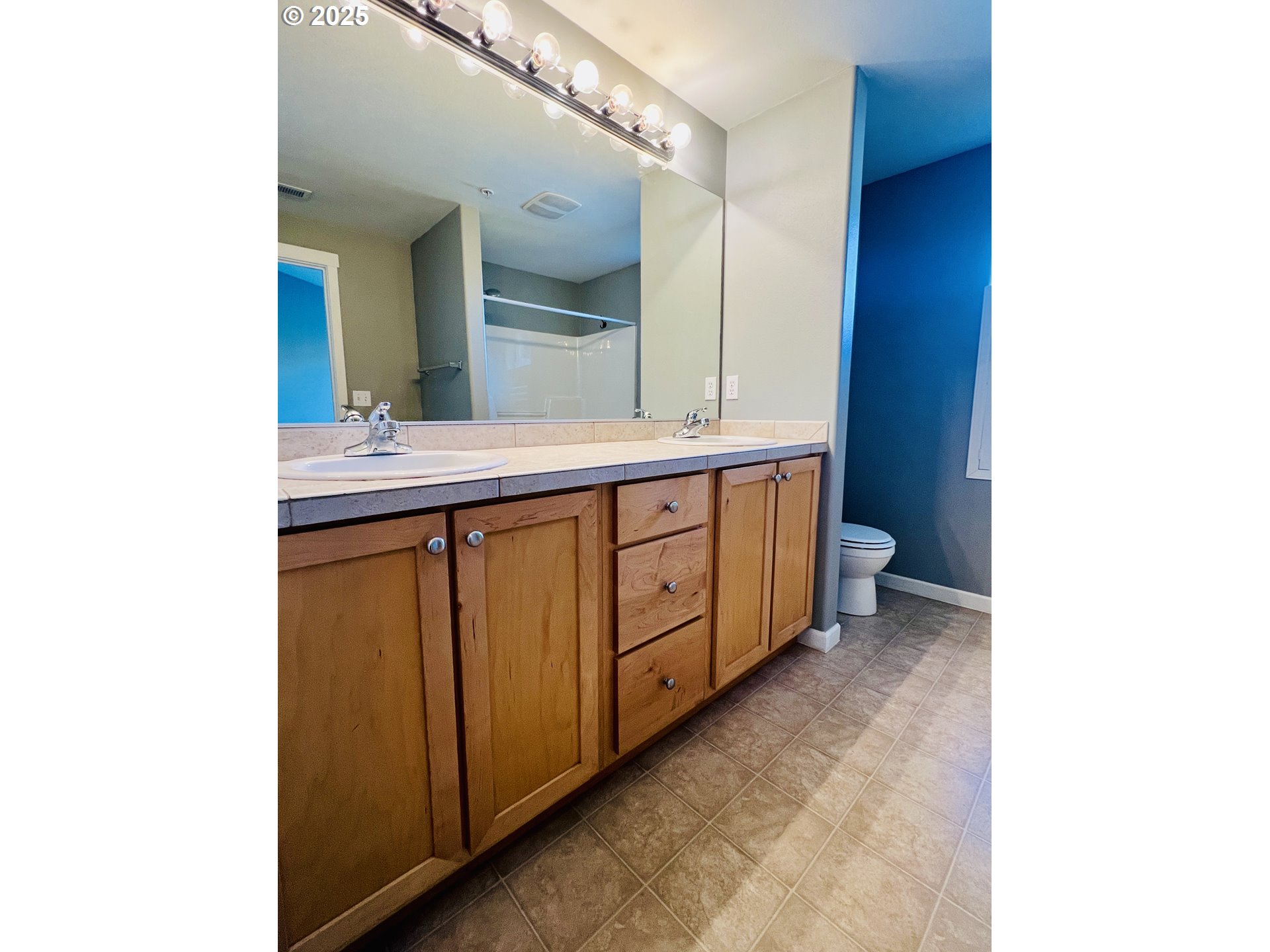 10723 Southwest Canterbury Lane, Unit 102 Portland, OR 97224 - Photo 20 of 30 a spacious bathroom with a double vanity sink and a mirror