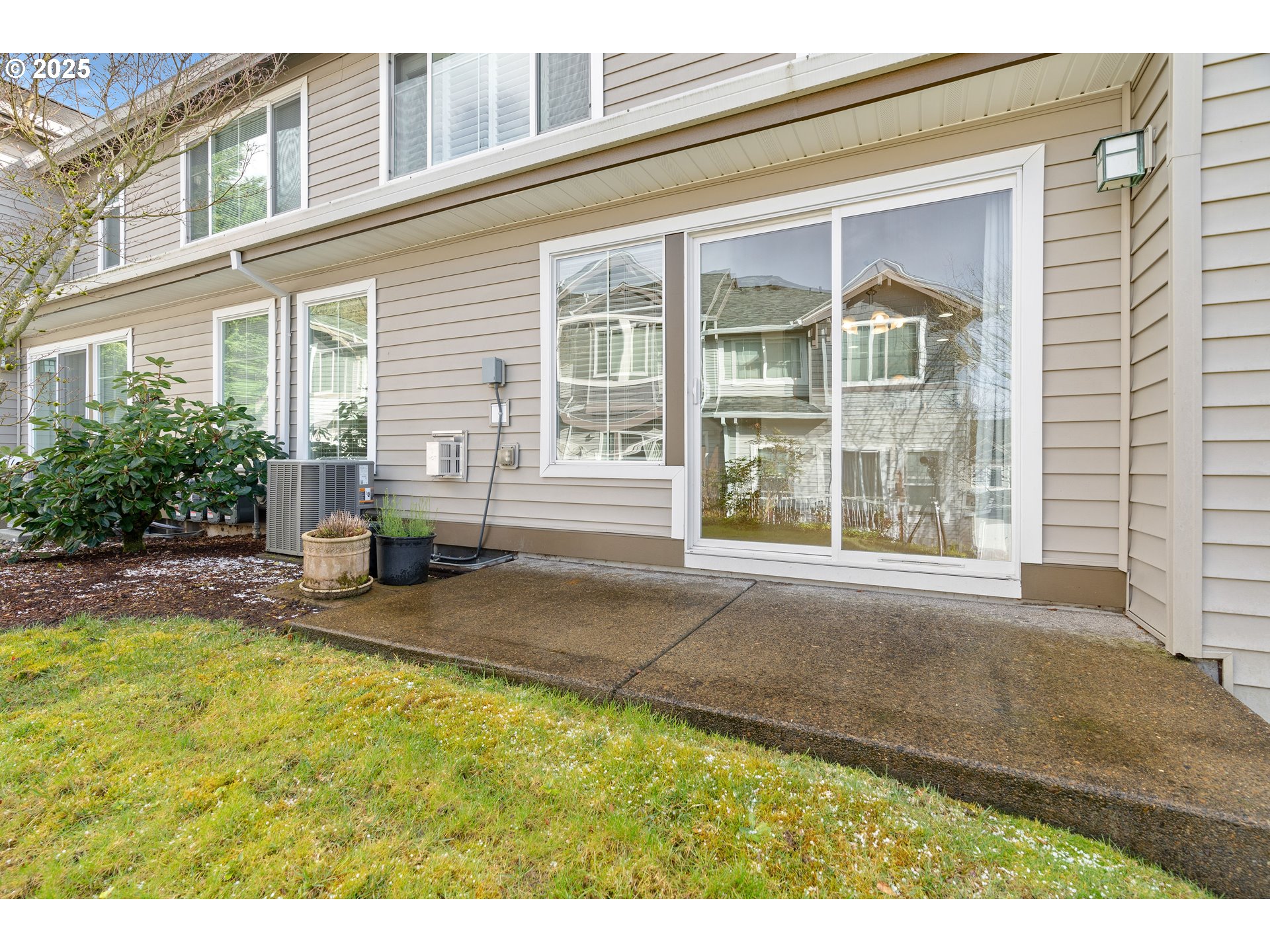 10723 Southwest Canterbury Lane, Unit 102 Portland, OR 97224 - Photo 28 of 30 a front view of a house with a yard and glass windows