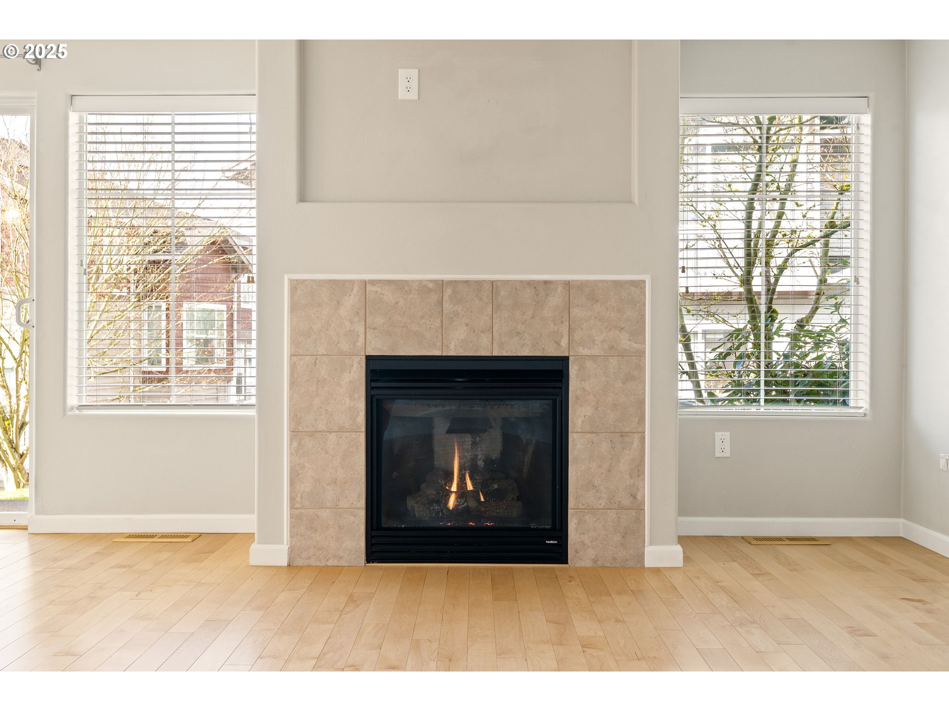 10723 Southwest Canterbury Lane, Unit 102 Portland, OR 97224 - Photo 4 of 30 a view of an empty room with a fireplace and a window