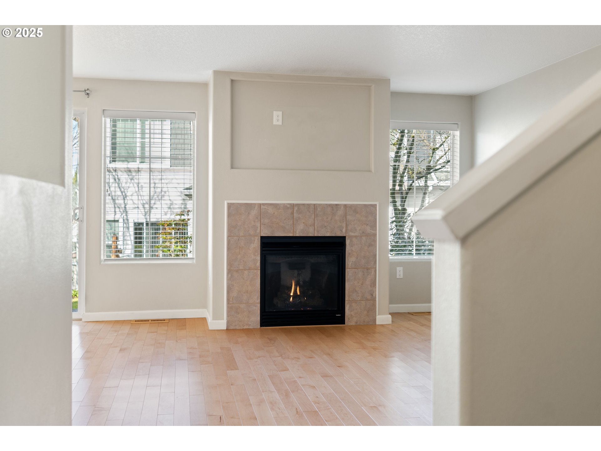 10723 Southwest Canterbury Lane, Unit 102 Portland, OR 97224 - Photo 5 of 30 a view of an empty room with wooden floor and a window